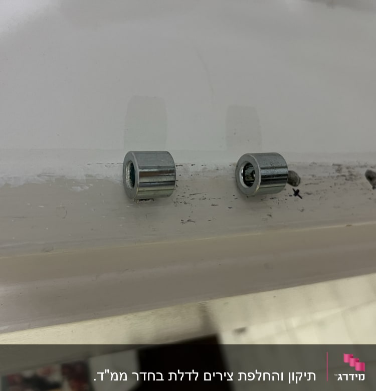 שני צילינדרים מתכתיים על משטח עץ לבן